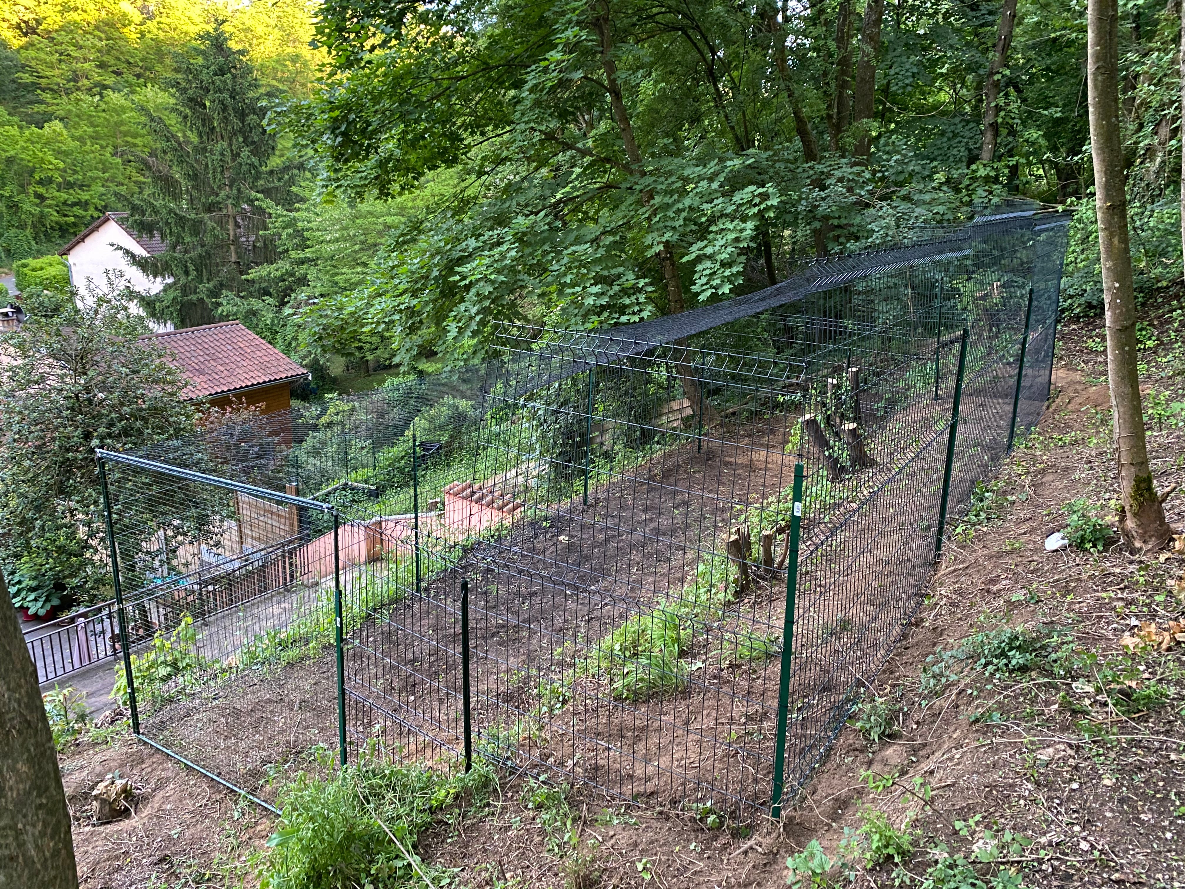 Cage noir dans jardin en pente